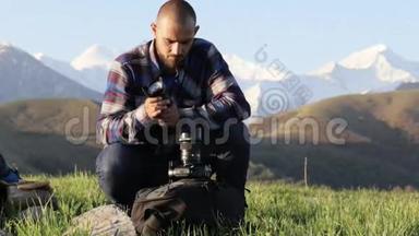 摄影师坐在室外专业摄像机上更换镜头。